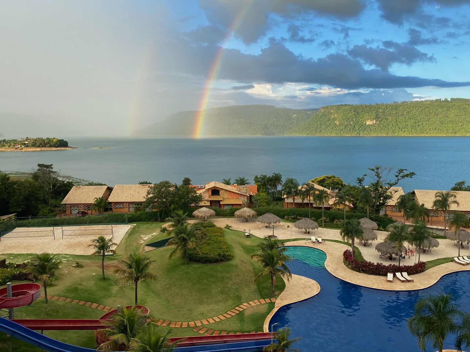 Das Resort Tayayá an einem Stausee mit einem Regenbogen am Himmel.