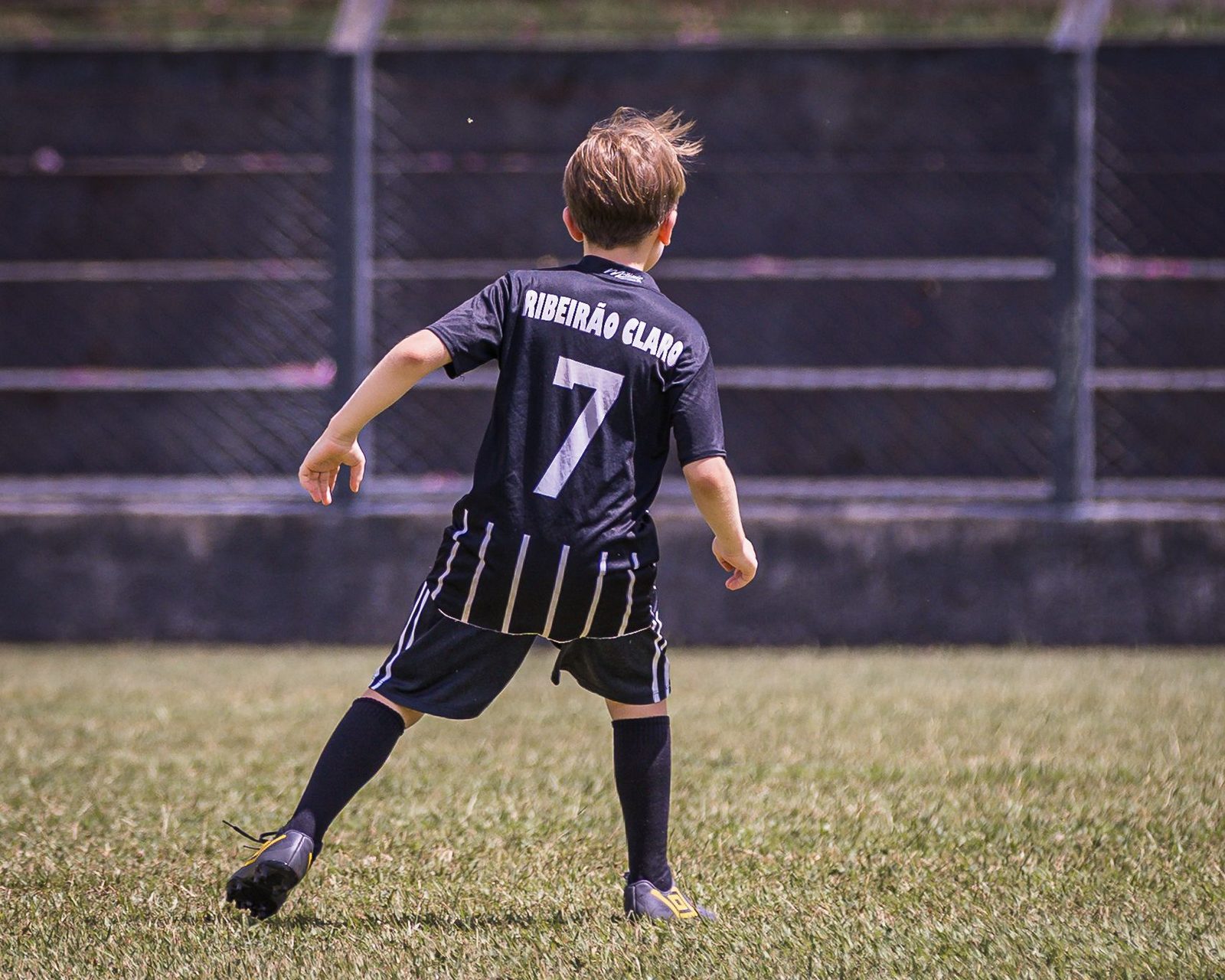 Ein junger Fußballer mit der Rückennummer 7 auf dem Platz in Ribeirão Claro, von hinten gesehen.